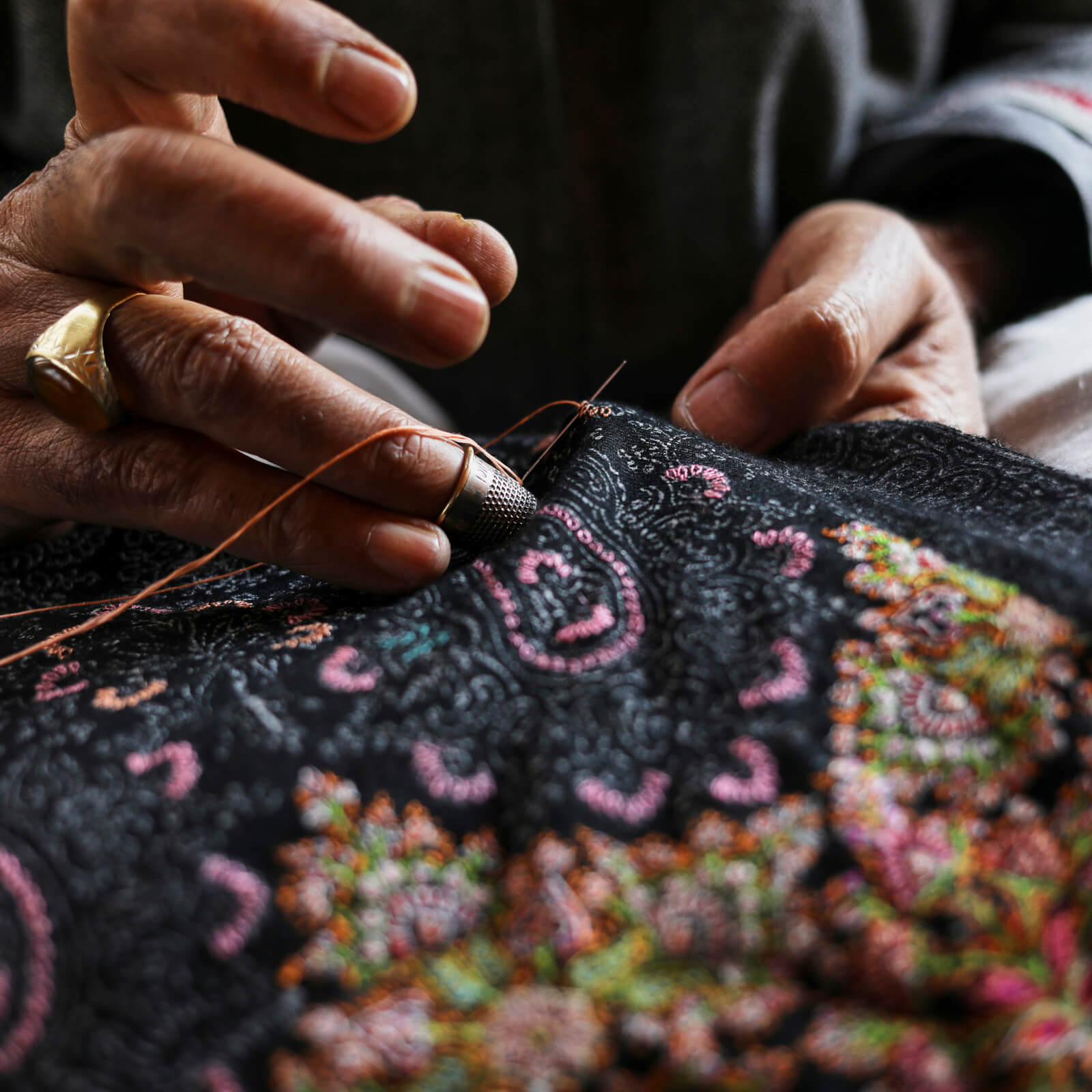Artisan hand embroidering a pashmina