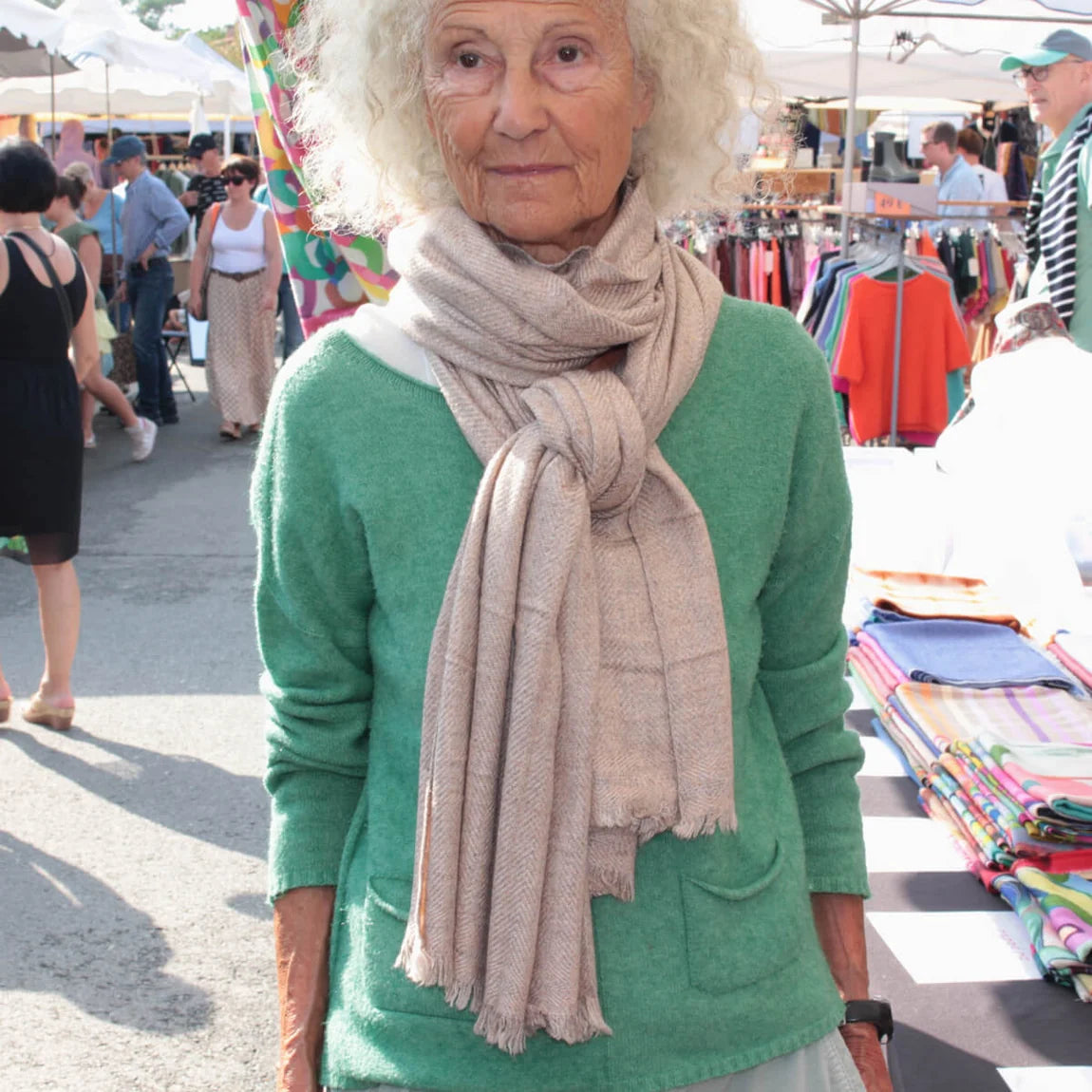 Woman wearing a beige cashmere shawl at a market